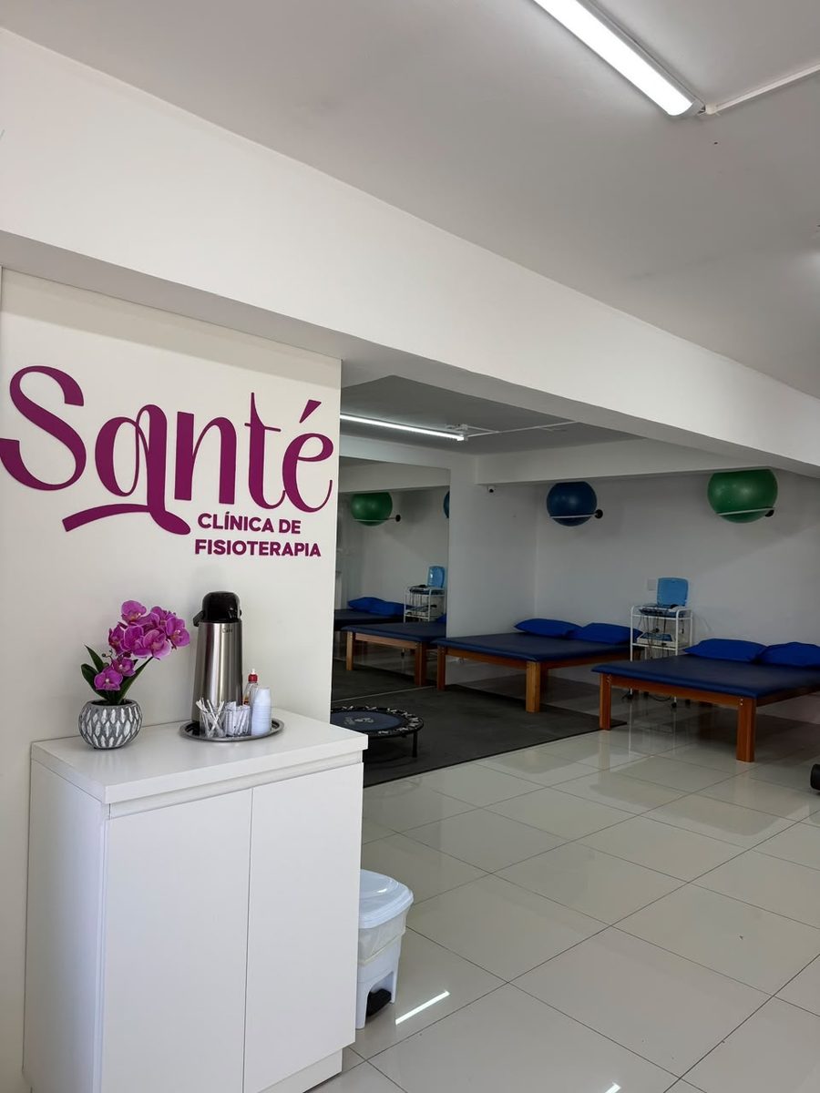 Entrada da clínica com a marca Santé e a sala de atendimento ao fundo